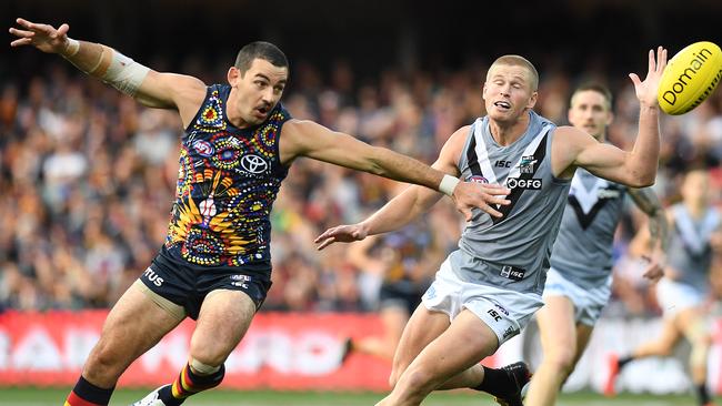 Crows co-captain Taylor Walker and opponent Tom Clurey in Showdown 47. Picture: AAP Image/Dylan Coker