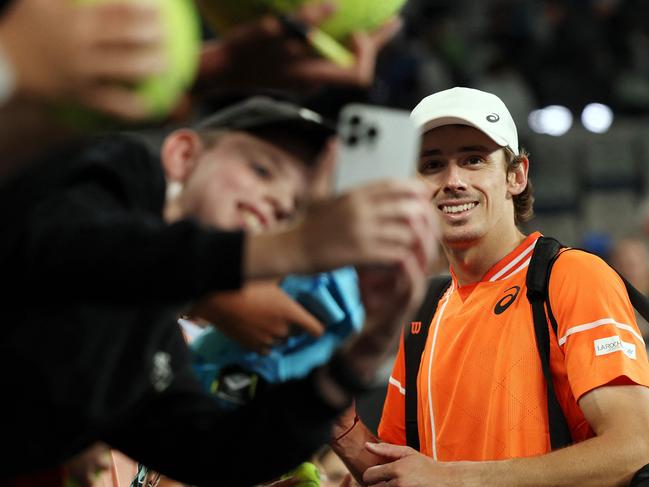 Fans take selfies with Australia's Alex De Minaur after his victory against Italy's Flavio Cobolli during their men's singles match on day six of the Australian Open tennis tournament in Melbourne on January 19, 2024. (Photo by Martin KEEP / AFP) / -- IMAGE RESTRICTED TO EDITORIAL USE - STRICTLY NO COMMERCIAL USE --