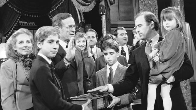 Senator Joe Biden holds his daughter Ashley while taking a mock oath of office from vice-president George HW Bush during a ceremony on Capitol Hill in 1985. Picture: AP