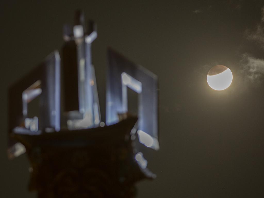 The partially-eclipsed moon rises against a tower with the name of God in Arabic "Allah," in Islamabad, Pakistan, Wednesday, July 17, 2019. (AP Photo/B.K. Bangash)