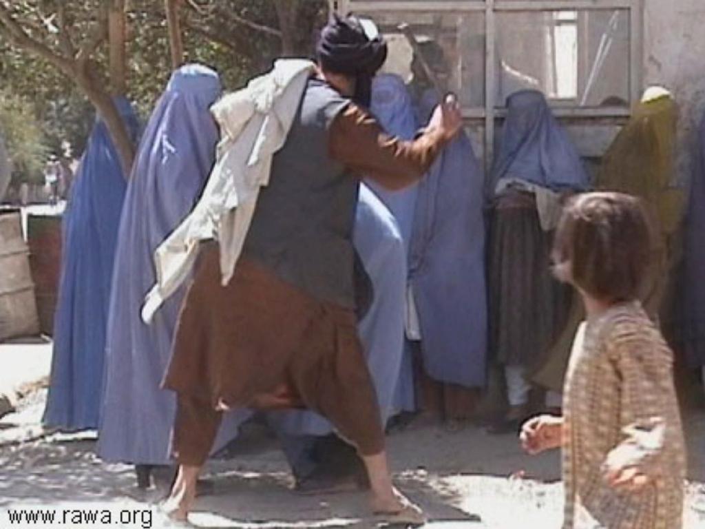 Afghan Taliban man beating women wearing burqas in Kabul, Afghanistan in September 2001. Picture: Revolutionary Association of the Women of Afghanistan