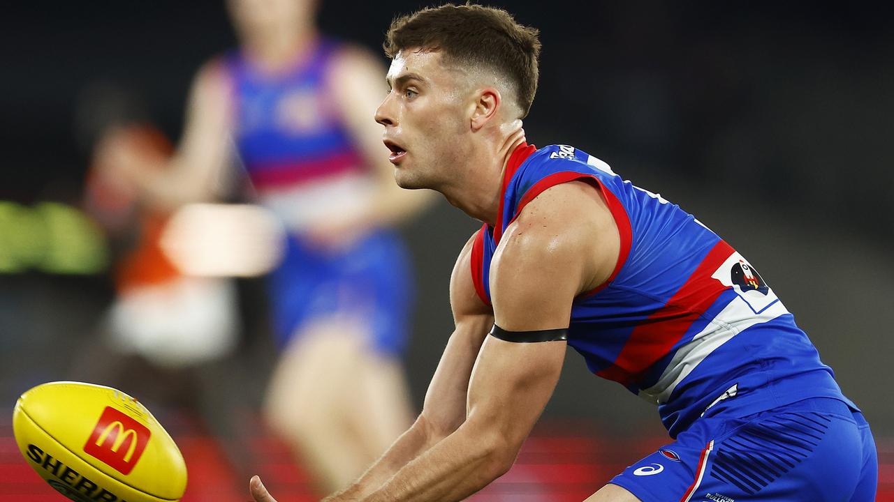 Josh Dunkley of the Bulldogs handballs during the round 22 AFL match between the Western Bulldogs and the Greater Western Sydney Giants at Marvel Stadium.