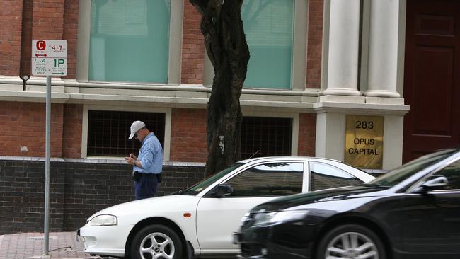 A parking inspector writes a ticken on Elizabeth St in Brisbane’s CBD.