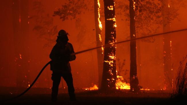 A firefighter works to save the Rural Fire Service headquarters at Colo Heights. Picture: Rohan Kelly