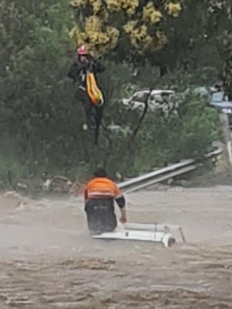 SES members winched a man to safety from the roof of a vehicle submerged in floodwater on Tuesday.