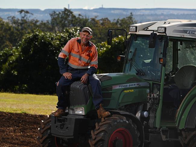 19/6/2024: Blackbutt Avocado grower Adrian Bettwieser , with the existing power station in the distance behind him,  reacts to the possibility of a nuclear power station being built in the future on the site of the Tarong coal power station, Blackbutt, QLDpic: Lyndon Mechielsen/The Australian