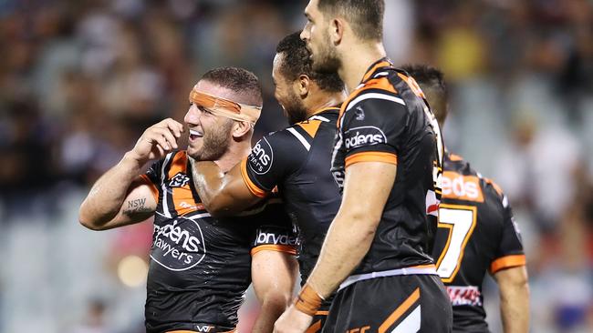 SYDNEY, AUSTRALIA - MARCH 24: Robbie Farah of the Tigers celebrates with his teammates after scoring a try during the round two NRL match between the Wests Tigers and the New Zealand Warriors at Campbelltown Stadium on March 24, 2019 in Sydney, Australia. (Photo by Mark Kolbe/Getty Images)