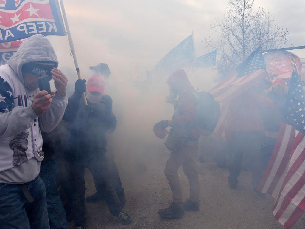 Trump supporters clash with police and security forces as they try to storm the US Capitol surrounded by tear gas in Washington, DC. Picture: AFP