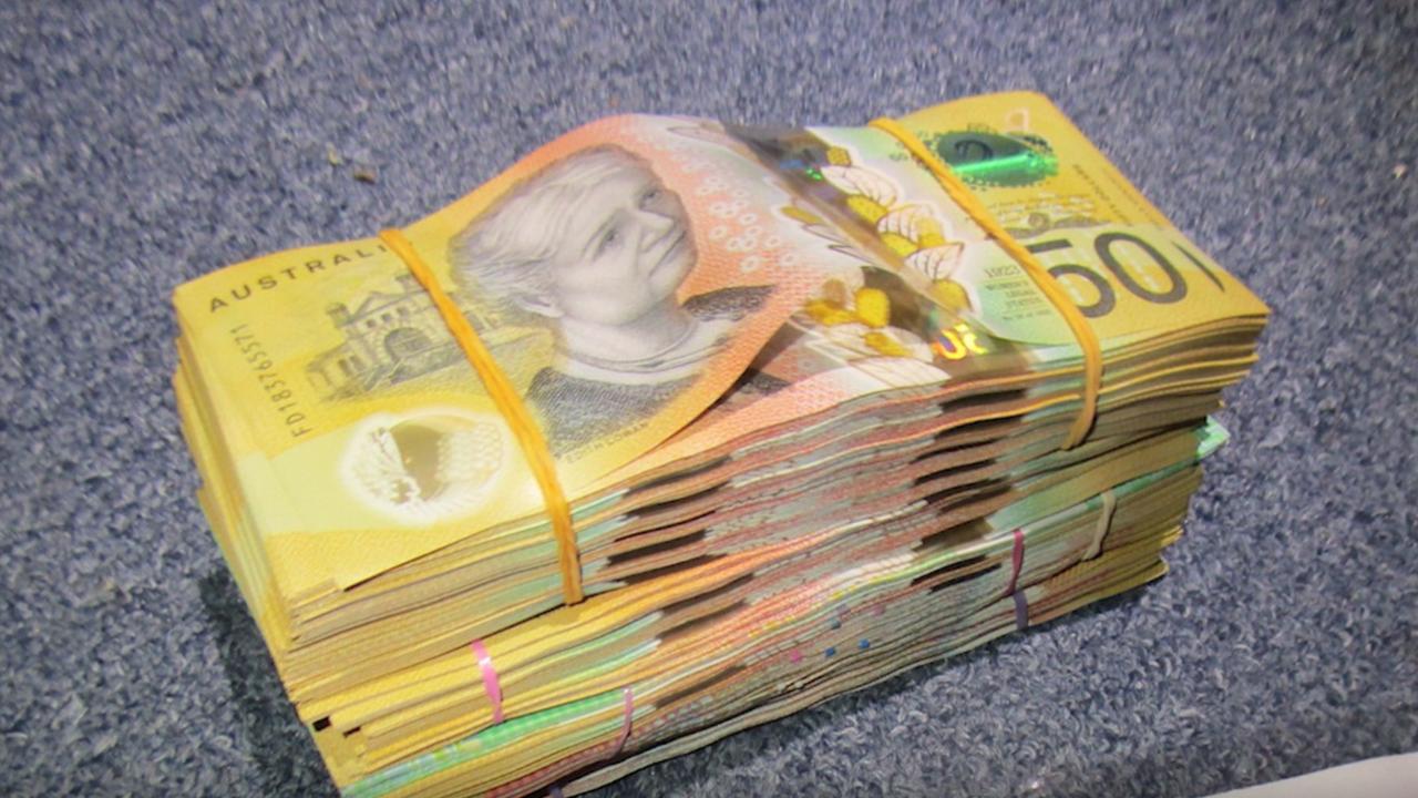 Major and Organised Crime Squad officers find a large amount of cash during a raid of a Cairns North house on Sunday, May 25. Picture: Queensland Police