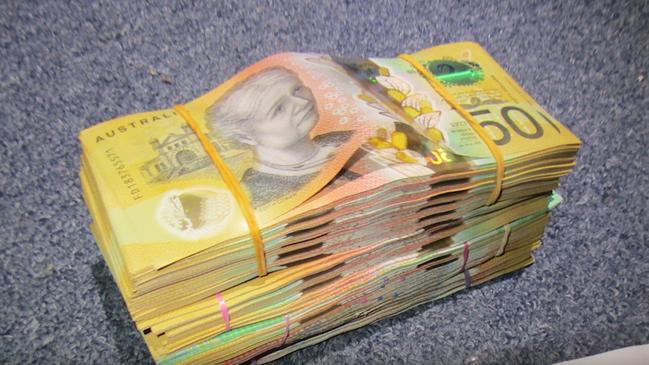 Major and Organised Crime Squad officers find a large amount of cash during a raid of a Cairns North house on Sunday, May 25. Picture: Queensland Police