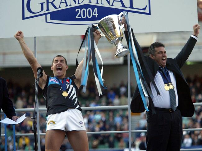 Warren Tredrea and Williams hold up the premiership cup.