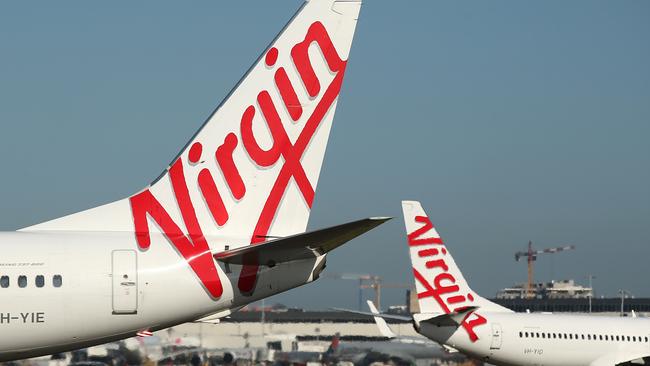 The Virgin Australia Holdings Ltd. logo is displayed on the tails of a Boeing Co. 737-800, left, and a Boeing Co. 737-8FE aircraft preparing to take off at Sydney Airport in Sydney, Australia, on Monday, Feb. 8, 2016. Virgin Australia is scheduled to announce half-year earnings on Feb. 11. Photographer: Brendon Thorne/Bloomberg