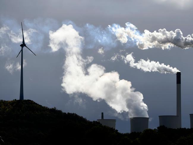 (FILES) This file photo taken on October 02, 2019 shows steam rising from a coal power plant of global energy supply company Uniper beside a wind turbine in Gelsenkirchen, western Germany. - German finance minister said on January 16, 2020 that coal plant operators would receive billions of euros in compensation for the planned shutdown of electrity generation using the fuel. (Photo by INA FASSBENDER / AFP)