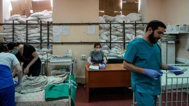 Working in the room of a children’s hospital protected by sandbags, medical staff treat a 13-year-old girl hit by a bullet as she was evacuating from Mariupol with her family on March 22. Photo: Emre Caylak / AFP.