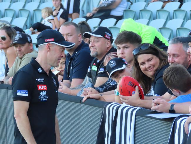 Collingwood coach Craig McRae signs autographs for fans. Picture: Jon Tuxworth