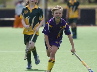 Macarthur Chronicle - Pictured: Julian Cook (Harrington Park) on the ball - Ingleburn Bulldogs (green yellow) versus Harrington Park Hurricanes (purple) - Macarthur District Juniors hockey finals 2014 held at Millwood Avenue, Narellan NSW Australia