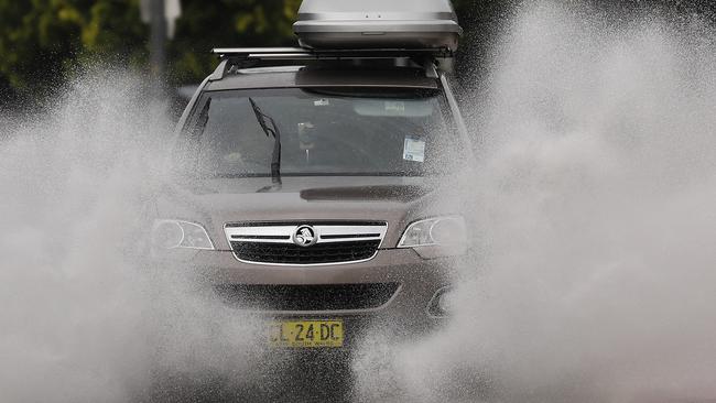 Cars on Pittwater Rd drive through flooding  Photos by Chris Pavlich for The Daily Telegraph