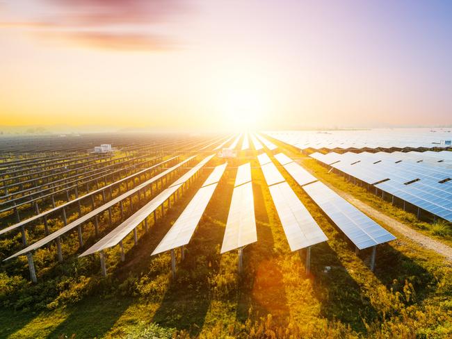 Photovoltaic modules reflect sunset light and clouds