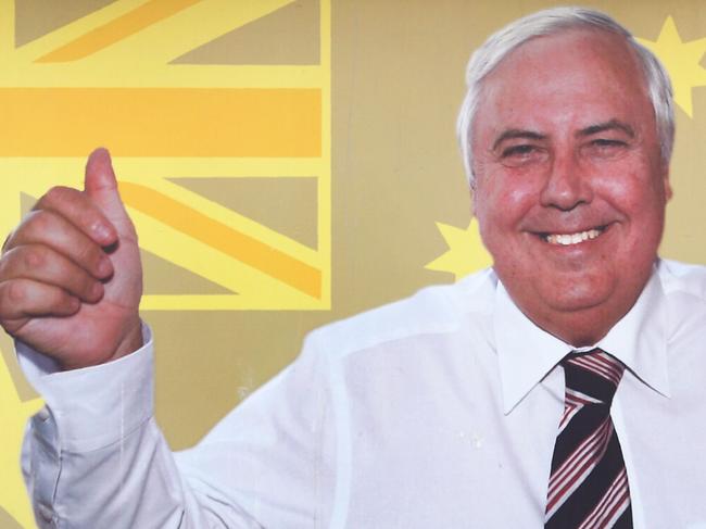 This photo taken on May 15, 2019 shows a man (L) taking a selfie in front of a billboard of United Australia Party leader Clive Palmer in Melbourne. - A brash, self-promoting billionaire with political ambition and a string of controversies in his wake, Clive Palmer not only sounds like Australia's answer to Donald Trump, that is exactly who he is modelling himself on. (Photo by William WEST / AFP) / TO GO WITH Australia-vote-2019-Palmer-US, PROFILE by Holly Robertson