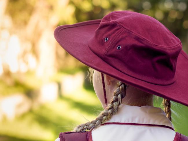 A girl wearing school uniform, white shirt, maroon backpack and maroon hat Back to school. Return to classrooms after COVID-19 outbreak in Australia