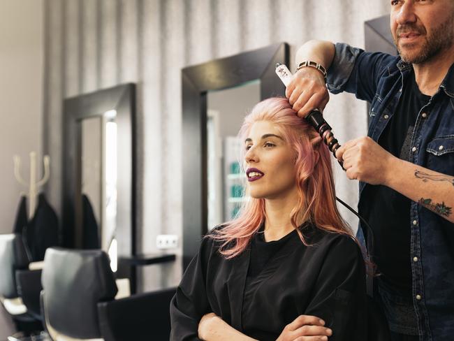 Beautiful woman getting haircut by hairdresser in the beauty.  istock image