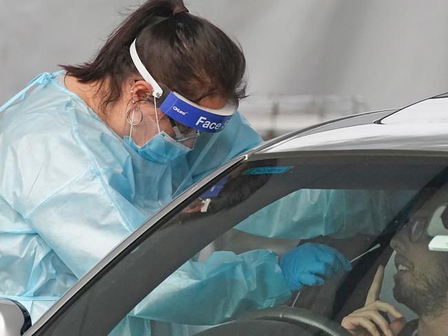 A medical worker takes a sample from a person at a drive-through COVID-19 pop-up testing clinic at the Keilor Community Hub in Melbourne, Sunday, May 31, 2020. A coronavirus cluster in Melbourne's northwest has infected 13 people across two homes, closed two schools and forced more than 100 students to self-isolate. (AAP Image/Scott Barbour) NO ARCHIVING