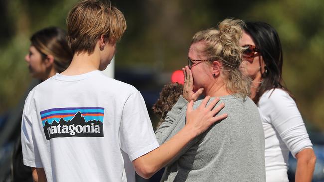 Janelle Law is comforted in the aftermath of a huge firestorm that forced her family from their home. Picture: Peter Wallis