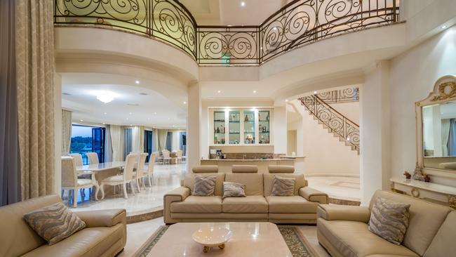 157 Sir Bruce Small Blvd, Benowa Waters, boasts a sweeping stone staircase, soaring ceilings and a chandelier that oozes opulence. 