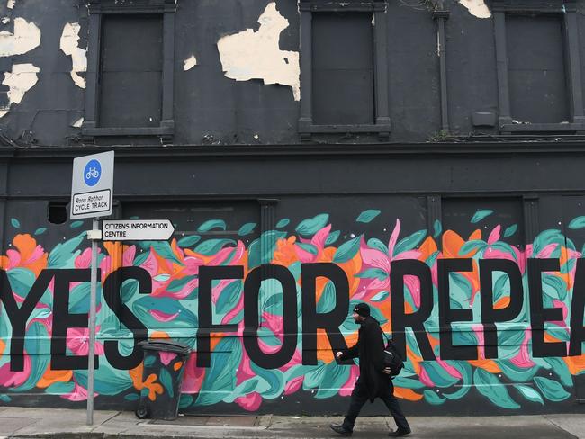 A man walks in front of a pro-choice mural urging a yes vote in the referendum to repeal the eighth amendment. Picture: AFP/Artur Widak