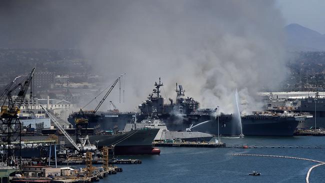 A fire burns on the amphibious assault ship USS Bonhomme Richard at Naval Base San Diego on July 12, 2020 in San Diego, California. There was an explosion on board the ship with multiple injuries reported. Photo: Sean M. Haffey/Getty Images/AFP