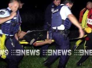 Police and emergency services crews carry the injured man. Picture: Nine News