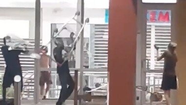 A group of youths and adults were filmed destroying the Coles entrance to the Palmerston Shopping Centre.