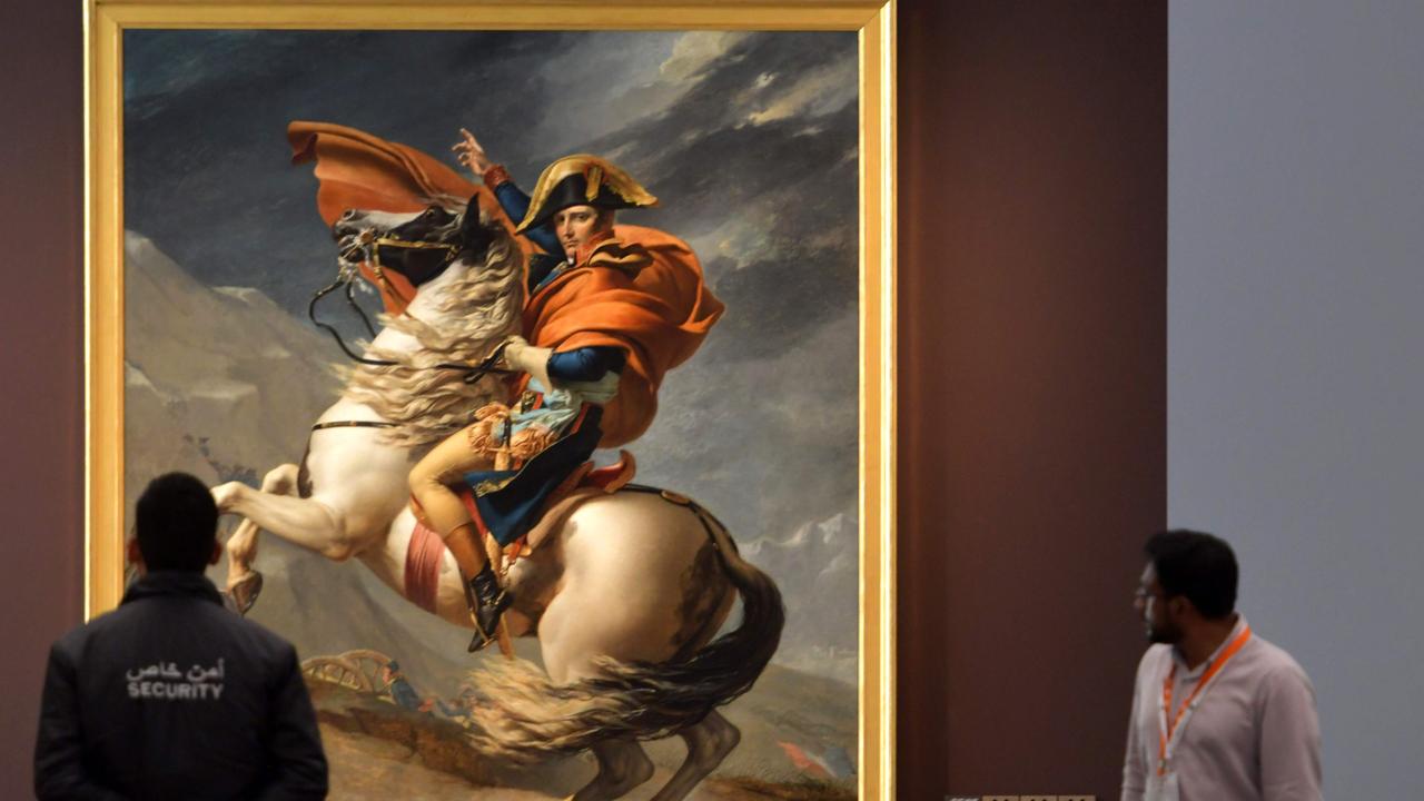 A seurity guard looks at the painting titled "Napoleon Bonaparte, First Consul, Crossing the Alps" by French artist Jacques-Louis David at the Louvre Abu Dhabi Museum. Napolean has remained an important figure in France. Picture: AFP PHOTO / Giuseppe Cacace