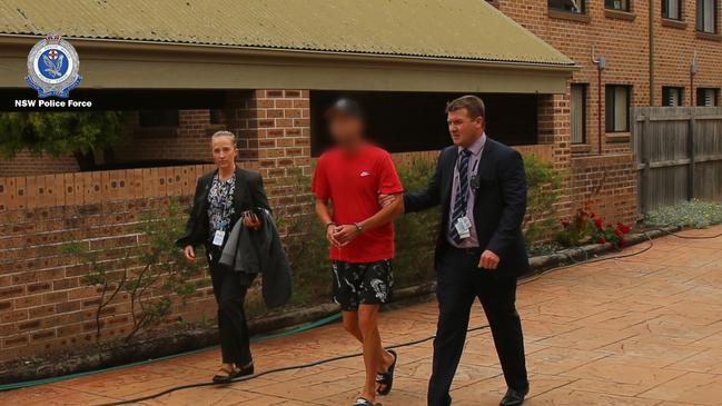 Shane Andrews, 39, is led away from his Richmond home by detectives after being arrested over allegations he lit five suspicious fires during the height of the bushfire season last summer. Picture: NSW Police