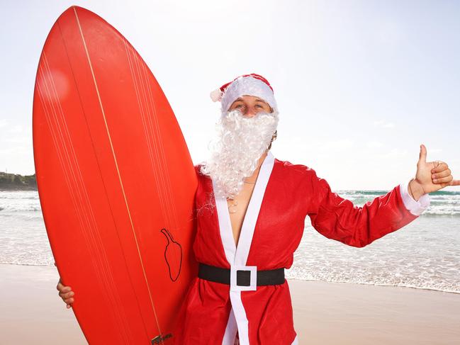 DAILY TELEGRAPH. DECEMBER 19, 2024.Pictured is The Harbord HotelÃs Santa going for a surf at Freshwater Beach today. Picture: Tim Hunter.