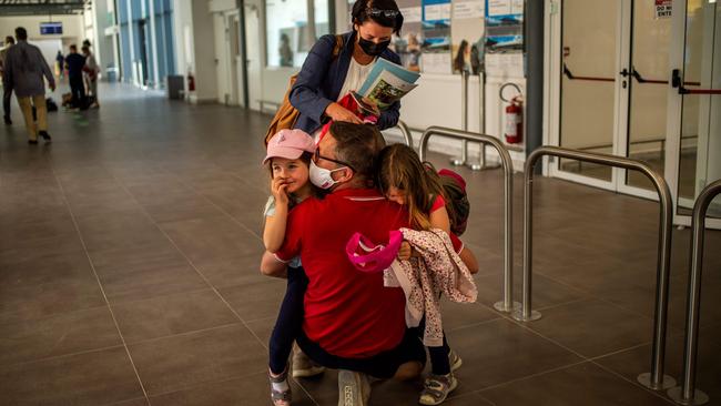 A man hugs his children upon their arrival from Frankfurt at the Corfu Airport Ioannis Kapodistrias on Corfu Island. Picture: AFP