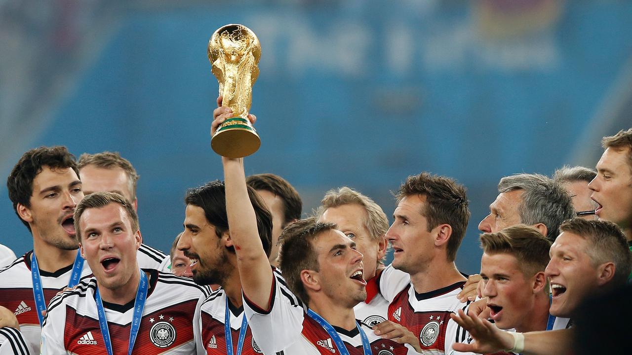 (FILES) This file photo taken on July 14, 2014 shows Germany's defender and captain Philipp Lahm (C) holds The World Cup as he poses with teammates after his team's victory in the final football match between Germany and Argentina for the FIFA World Cup at The Maracana Stadium in Rio de Janeiro. Germany weekly sports magazine Sports Bild reported on February 7, 2017 Bayern Munich's defender Philipp Lahm will retire at the end of the season and also that he would not be taking the position of Sports Director at the club. / AFP PHOTO / ADRIAN DENNIS