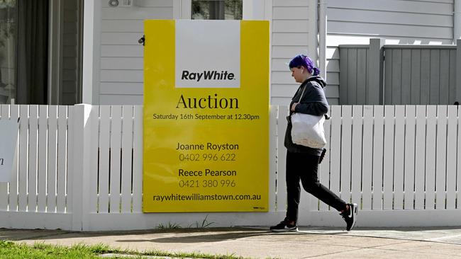 A woman walks past an auction sign outside a house in Melbourne on September 5, 2023 as the Reserve Bank of Australia (RBA) prepares to make it's monthly monetary policy decision on interest rates. (Photo by William WEST / AFP)