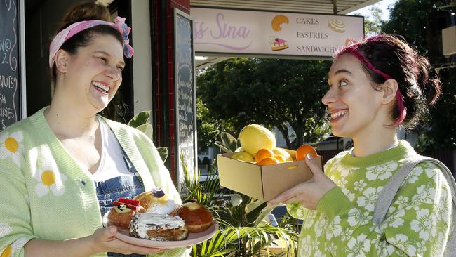 Cafe owner Sina Klug with regular customer Avalon Llewellyn exchange oranges and lemons for cafe food. Picture: John Appleyard