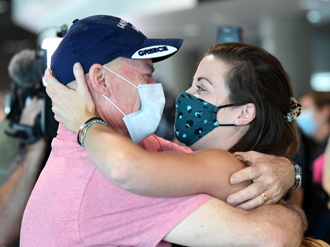 BRISBANE, AUSTRALIA - DECEMBER 13: Paul Gimpel hugs his daughter Rebecca Underhill after she arrived on the first flight from Sydney into Brisbane's domestic terminal since border restrictions have eased overnight on December 13, 2021 in Brisbane, Australia. Queensland's border is now open to fully vaccinated domestic travelers into the state without needing to quarantine. Unvaccinated arrivals must quarantine for 14 days. (Photo by Dan Peled/Getty Images)