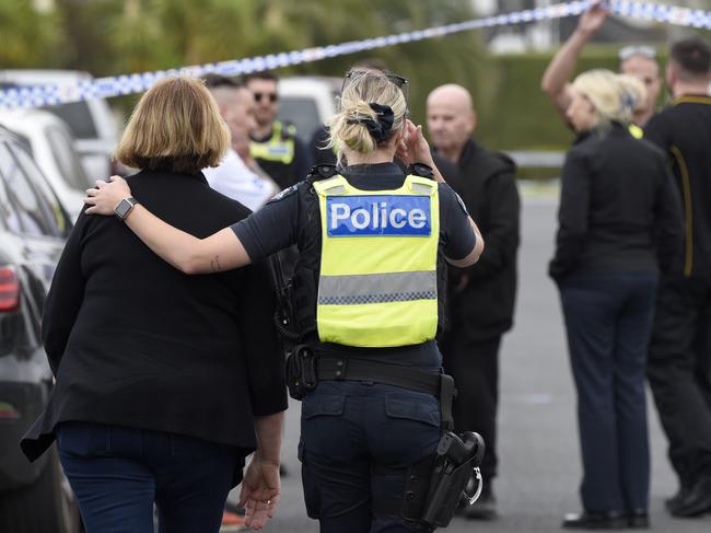 A police officer comforts a woman on the scene of Mr Latorre’s murder. Picture: Andrew Henshaw