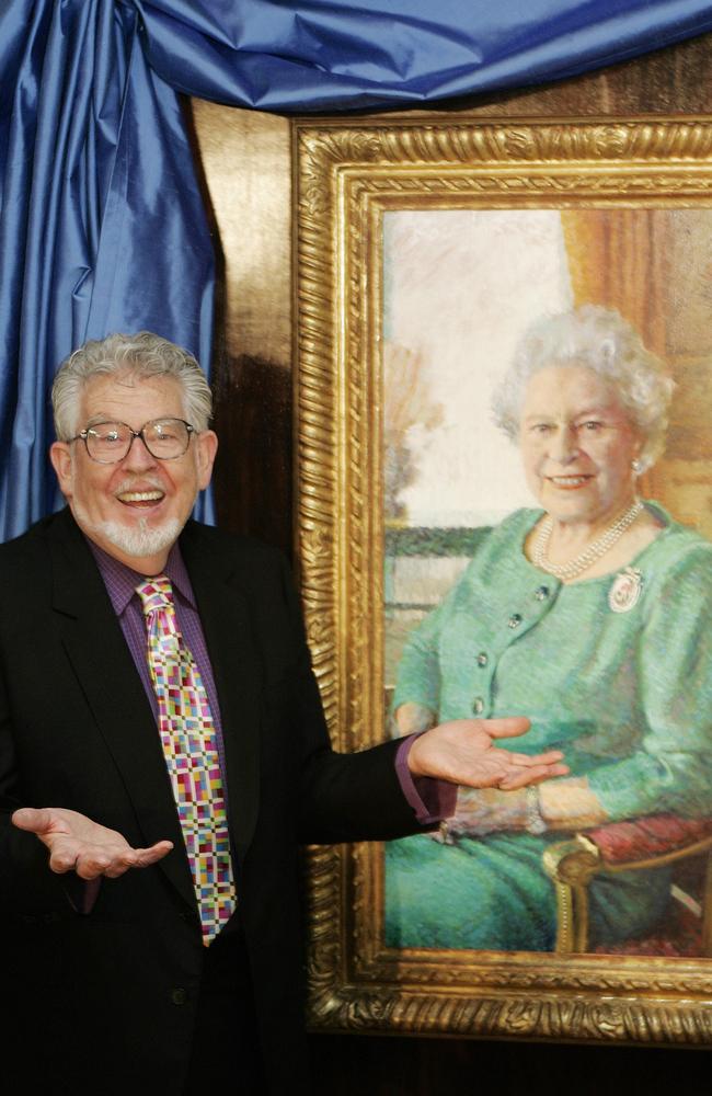 Rolf Harris with his portrait of the late Queen at its unveiling at Buckingham Palace. The painting was to celebrate Her Majesty's 80th birthday in 2006. Picture: AP