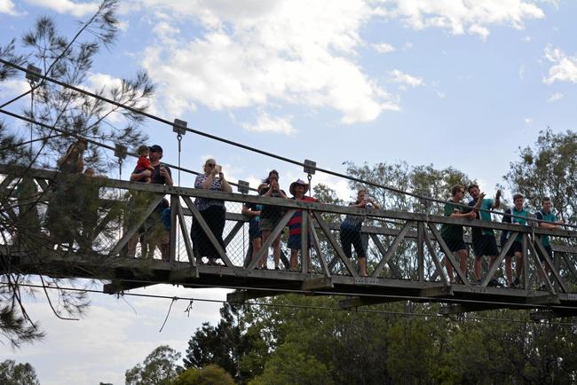 Laidley residents watch from the Nada Lagoon bridge as helicopters fill up with water to battle the Laidley fires. Picture: Ebony Graveur