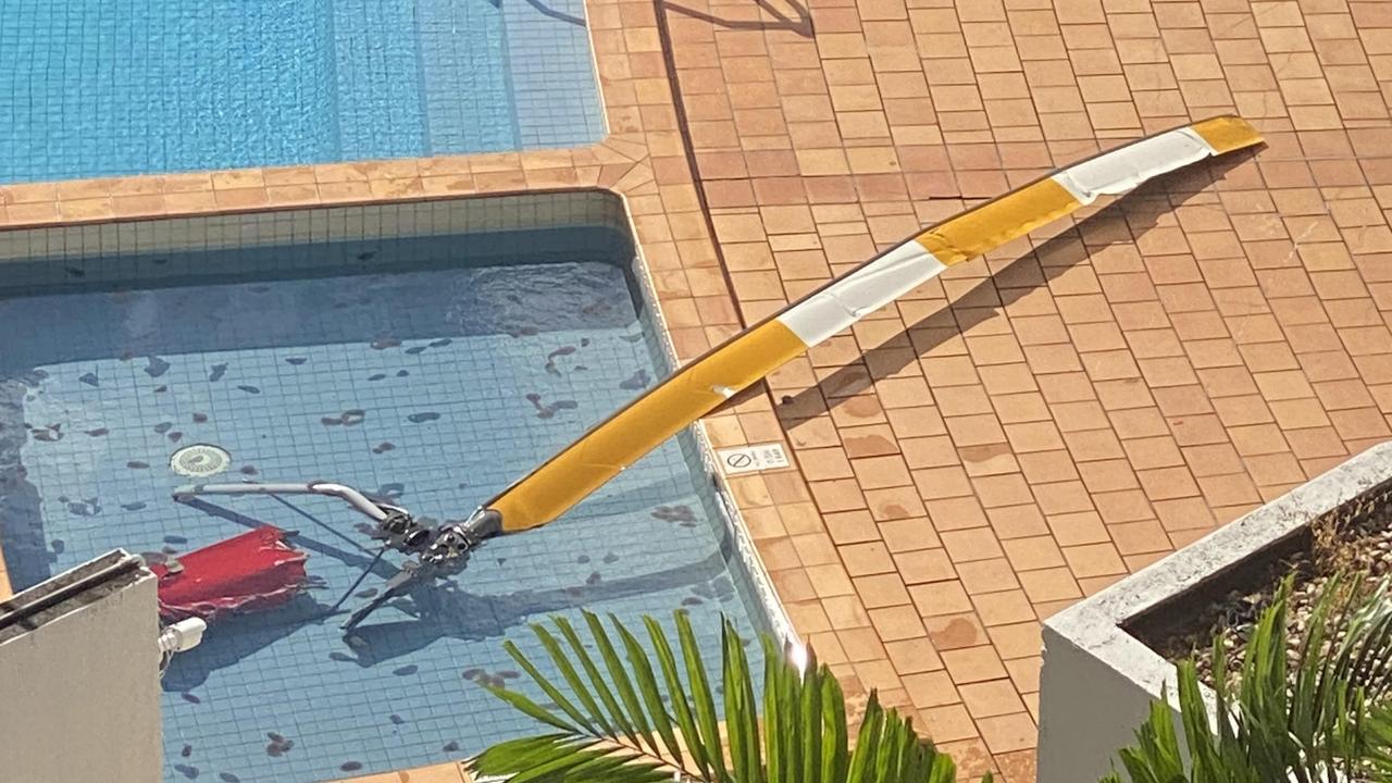 The rotor and part of the tail section of a helicopter lie in the pool of the Double Tree Hilton on the Cairns Esplanade. Photo: Ian Mullins