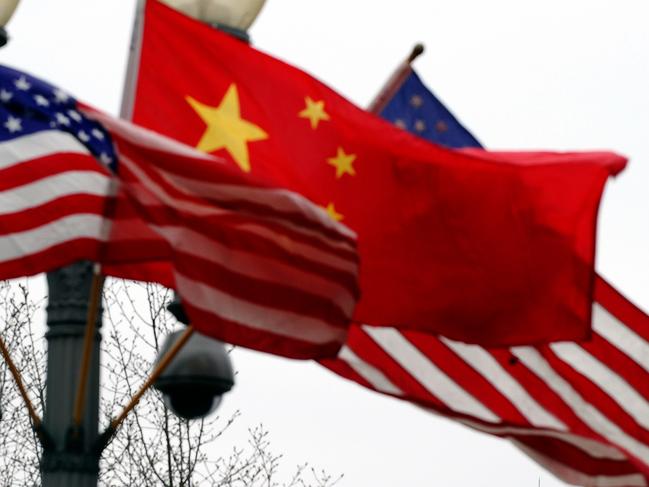 (FILES) In this file photo taken on January 17, 2011 a Secret Service agent guards his post on the roof of the White House as a lamp post is adorned with Chinese and US national flags in Washington, DC. - The United States secretly expelled two Chinese embassy officials in September after they drove onto a sensitive military base in Virginia, The New York Times reported on December 15, 2019.The newspaper, which cited people with knowledge of the episode, said it appeared to be the first time in more than 30 years that the US has expelled Chinese diplomats on suspicion of espionage. (Photo by Jewel SAMAD / AFP)