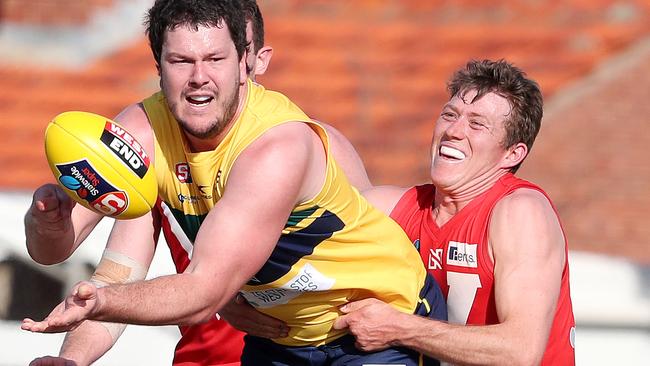 North Adelaide’s Campbell Combe applies a typically strong tackle on Eagles ruckman Jarrad Redden, Picture: Sarah Reed