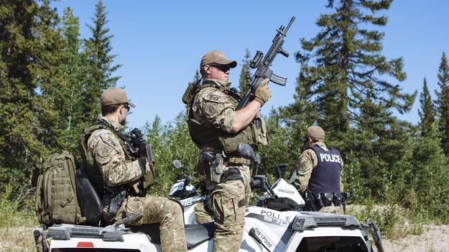 Members of the Royal Canadian Mounted Police Emergency Response Team prepare to search an area near where the burned out Toyota Rav4 was found. Picture: Angus Mordant