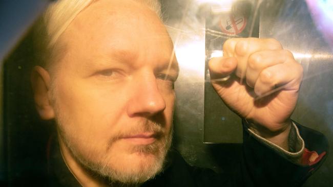 Assange gestures from the window of a prison van as he arrives at Southwark Crown Court in London in May, 2019.