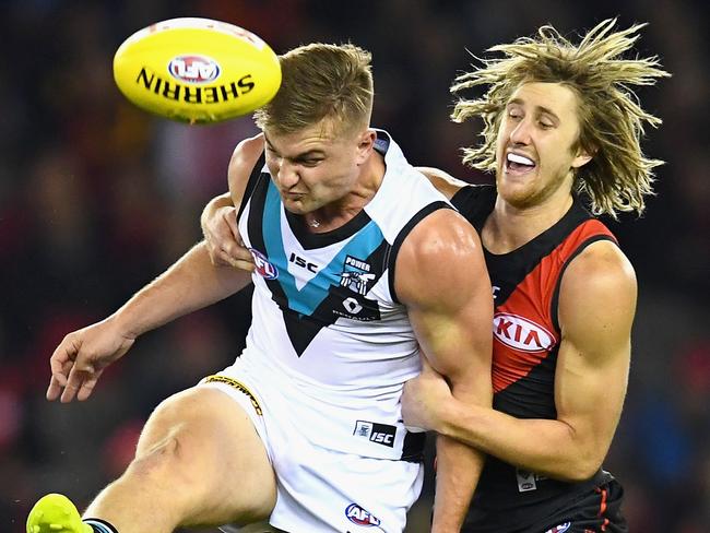 MELBOURNE, AUSTRALIA - JUNE 10:  Ollie Wines of the Power kicks whilst being tackled Dyson Heppell of the Bombers during the round 12 AFL match between the Essendon Bombers and the Port Adelaide Power at Etihad Stadium on June 10, 2017 in Melbourne, Australia.  (Photo by Quinn Rooney/Getty Images)