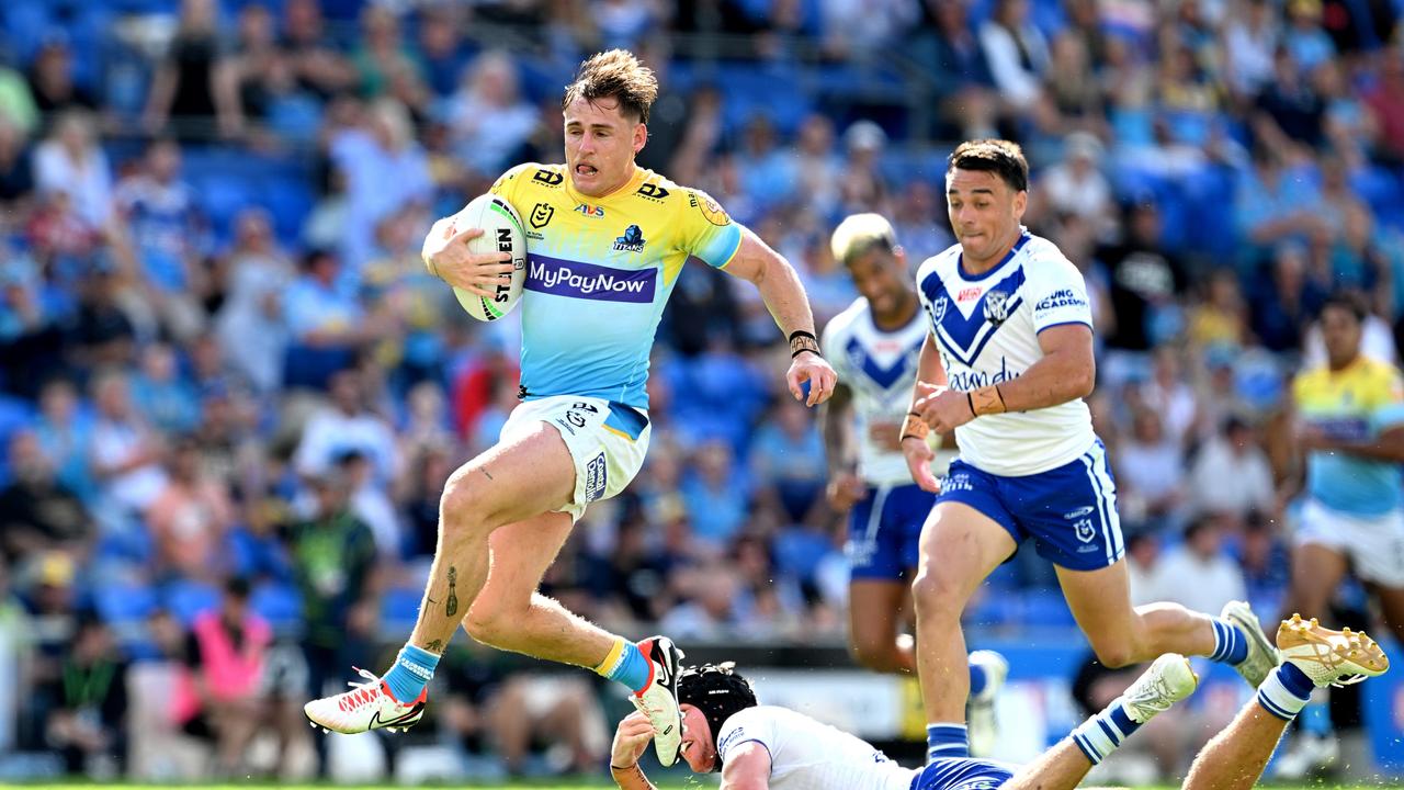 GOLD COAST, AUSTRALIA - SEPTEMBER 03: AJ Brimson of the Titans breaks away from the defence of Matt Burton of the Bulldogs during the round 27 NRL match between the Gold Coast Titans and Canterbury Bulldogs at Cbus Super Stadium on September 03, 2023 in Gold Coast, Australia. (Photo by Bradley Kanaris/Getty Images)